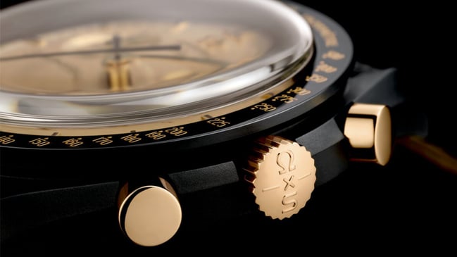 MoonSwatch Mission to the Moon 1969 gold dial detail — vertically satin-brushed 18k MoonShine Gold dial showing AU 750 engraving and tachymeter scale