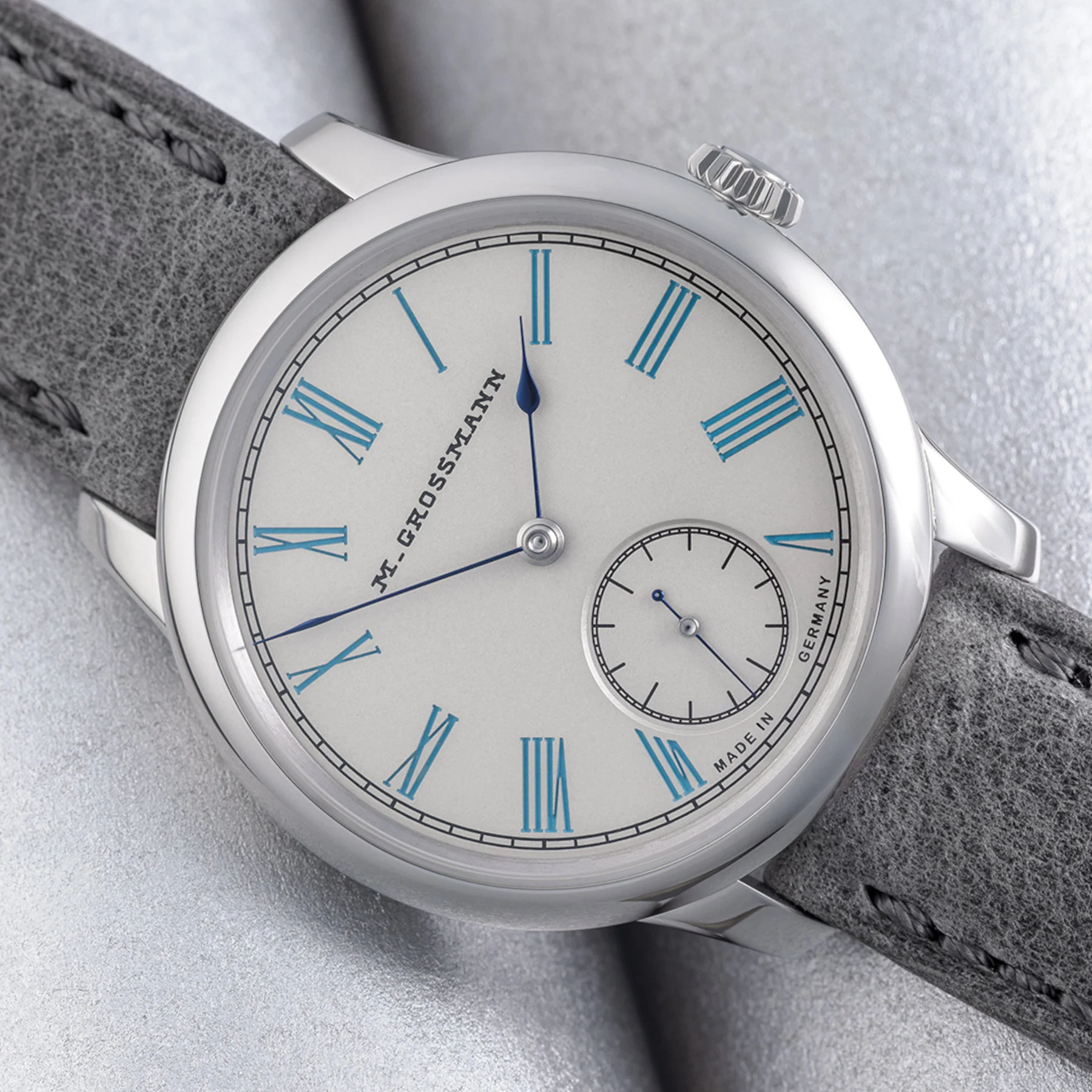 Moritz Grossmann Tefnut 36 Silver-Plated by Friction Turquoise Blue dial — silver-plated beige background with turquoise Roman numerals, handmade blue-annealed hands