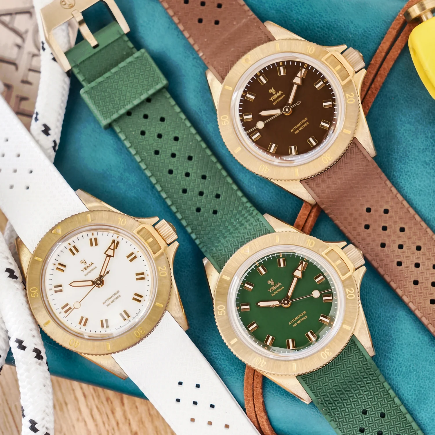 Yema Superman Bronze CMM.10 all three colours — brown, green and white glossy gilt dials side by side on 39mm bronze cases with matching FKM Viton rubber straps