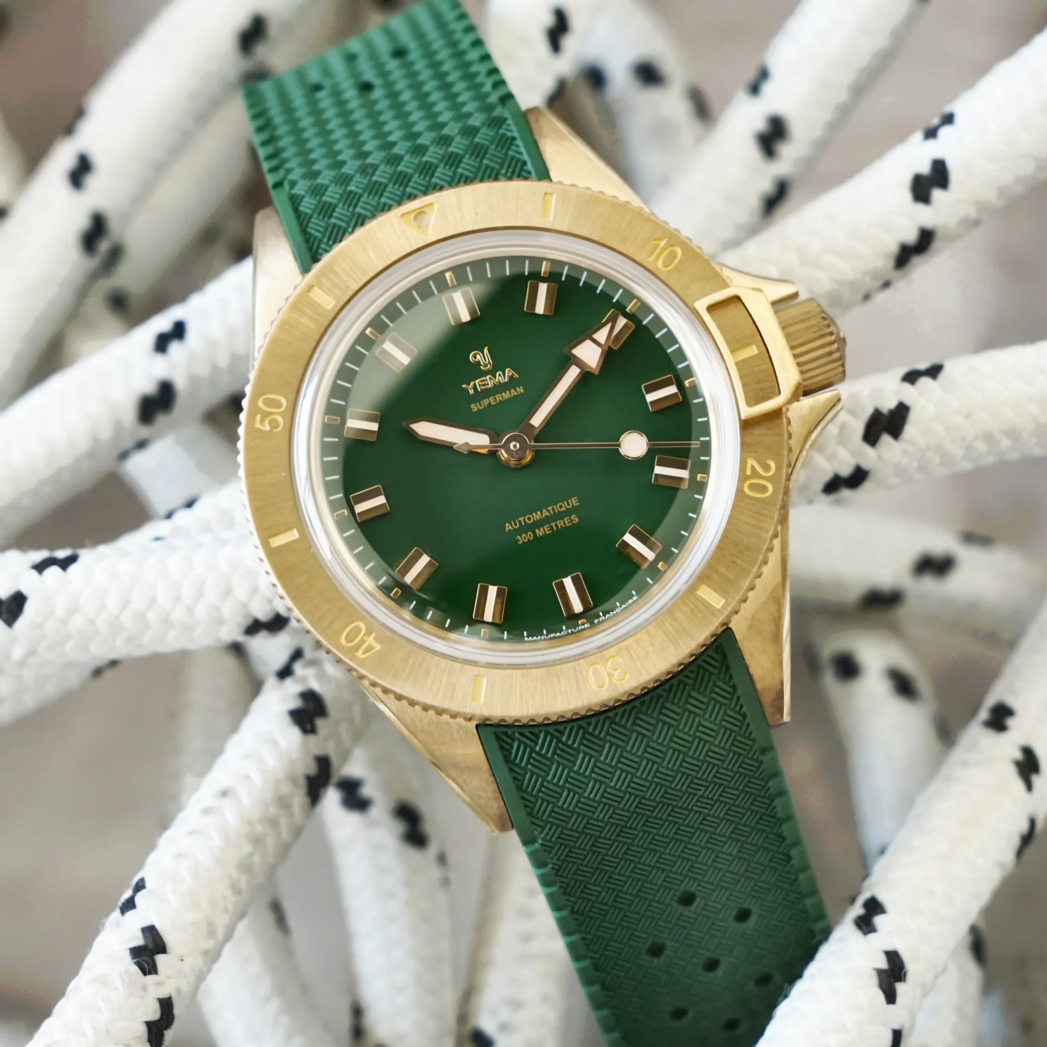 Yema Superman Bronze CMM.10 green dial — deep forest green glossy lacquered surface with gilt markers and bronze case, integrated green FKM Viton strap